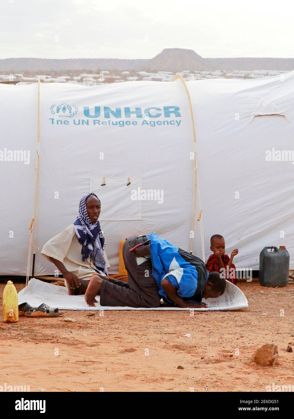 A Somali refugee man prays outside his tent at the Kobe refugee camp 60 km (37.3 miles) from Dolo Ado near the Ethiopia-Somalia border, August 10, 2011. The U.N. refugee agency and a government agency have established four camps along the Ethiopian border with Somalia to accommodate a refugee population that now exceeds 120,000 most of whom are victims of drought and famine; the worst in decades, and has affected about 12 million people across the Horn of Africa. REUTERS/Thomas Mukoya (ETHIOPIA - Tags: ENVIRONMENT DISASTER RELIGION) Stock Photo