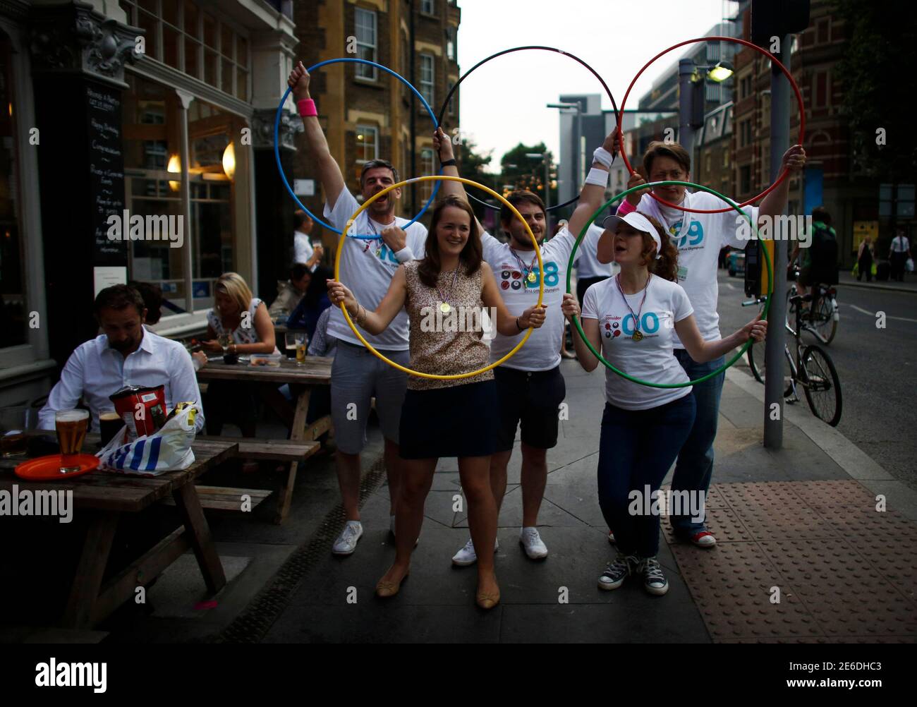 People hold hula hoops in a way that resembles the Olympic rings, to mock the copyright infringement rules on the logo during the night of the opening ceremony of London 2012 Olympic Games in London July 27, 2012. REUTERS/Mark Blinch (BRITAIN - Tags: SPORT OLYMPICS) Stock Photo