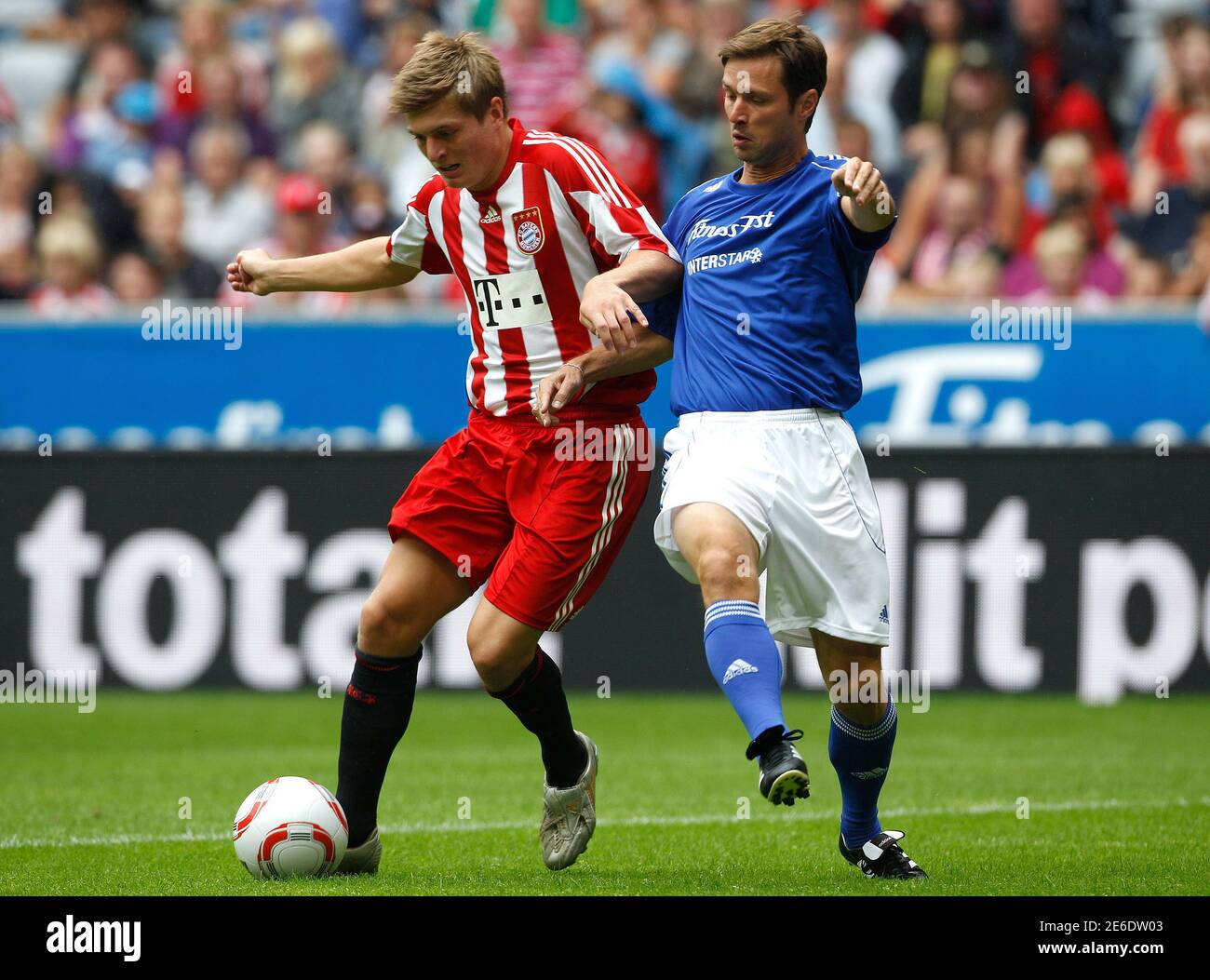 Bayern Munich's Toni Kroos (L) is tackled by Harald Cerny of the winter Olympic sport stars during a friendly soccer match in the Allianz Arena in Munich August 8, 2010.  REUTERS/Michaela Rehle (GERMANY - Tags: SPORT SOCCER) Stock Photo