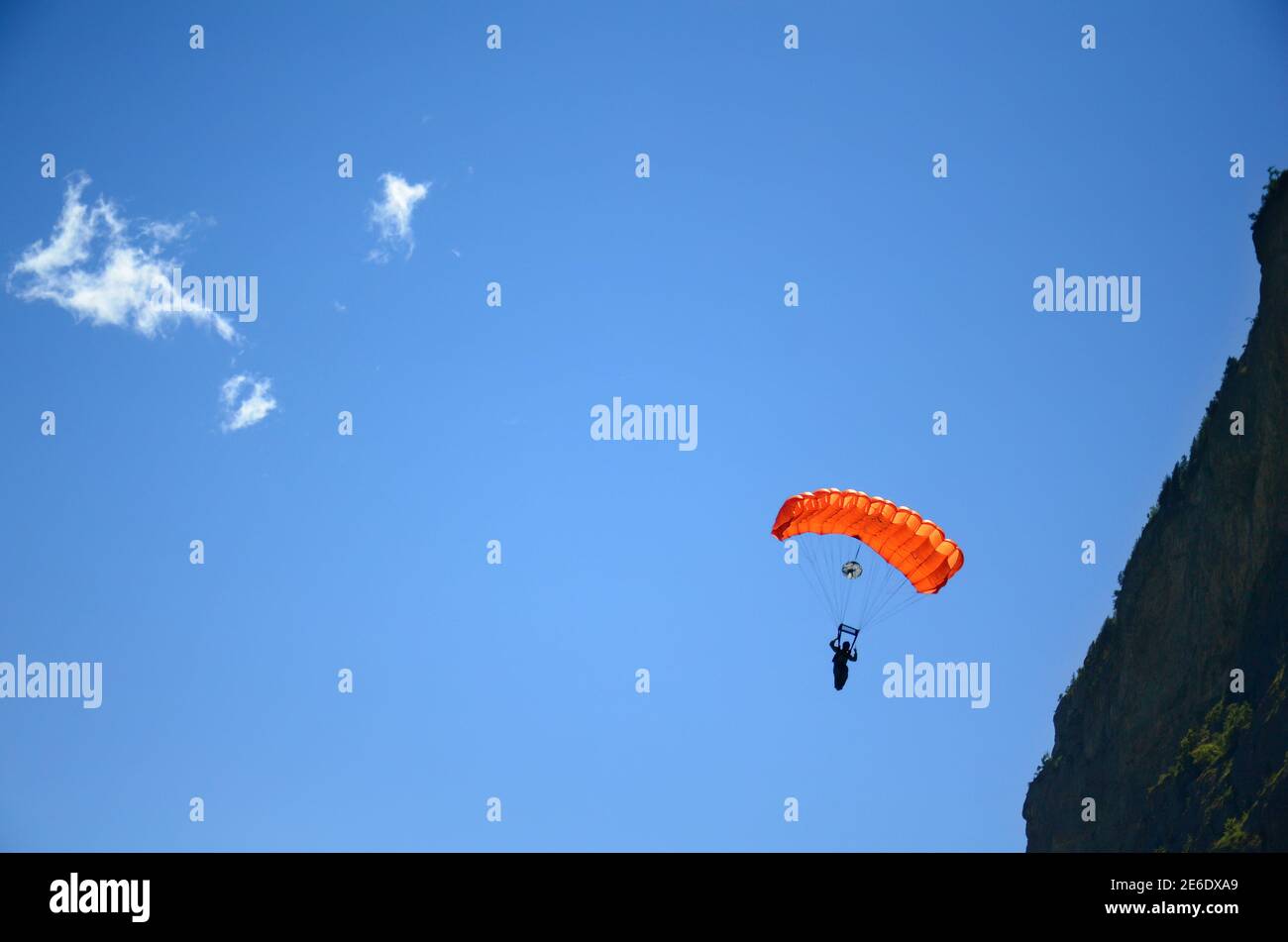 Silhouette of skydiver with parachute against blue sky. Interlaken, Switzerland Stock Photo