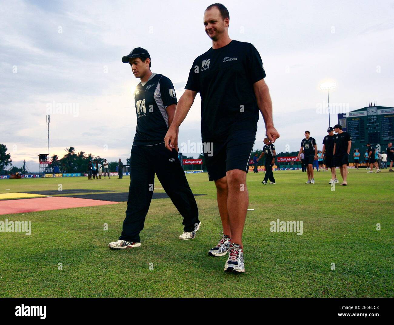 New Zealand's captain Ross Taylor (L) and his team's bowling coach Shane  Jurgensen walk on the field as rain delayed the fourth one-day  international cricket match between Sri Lanka and New Zealand