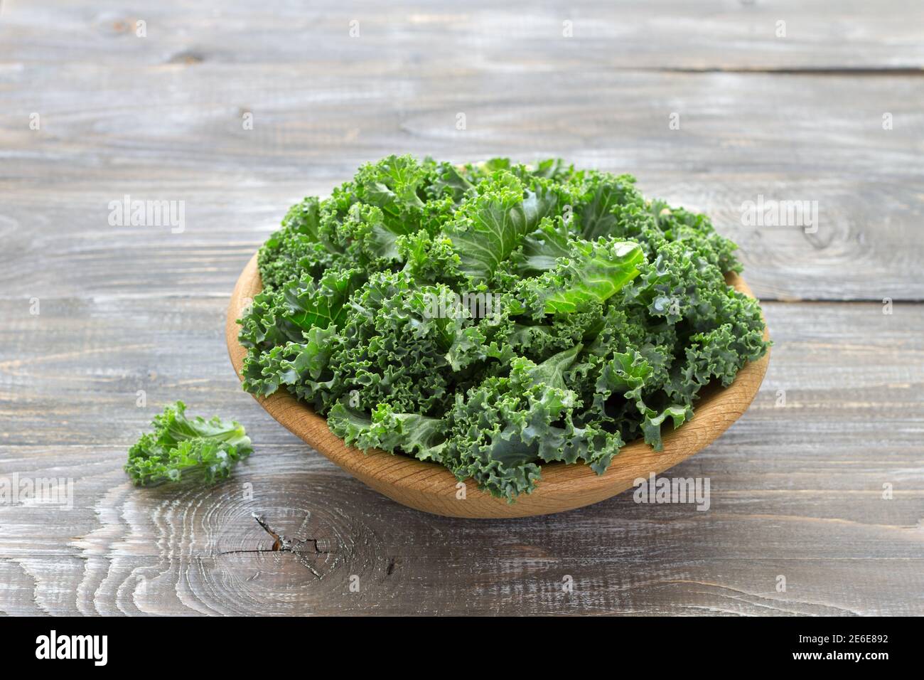 Fresh green curly kale leaves on a wooden table. selective focus. rustic style. healthy vegetarian food Stock Photo