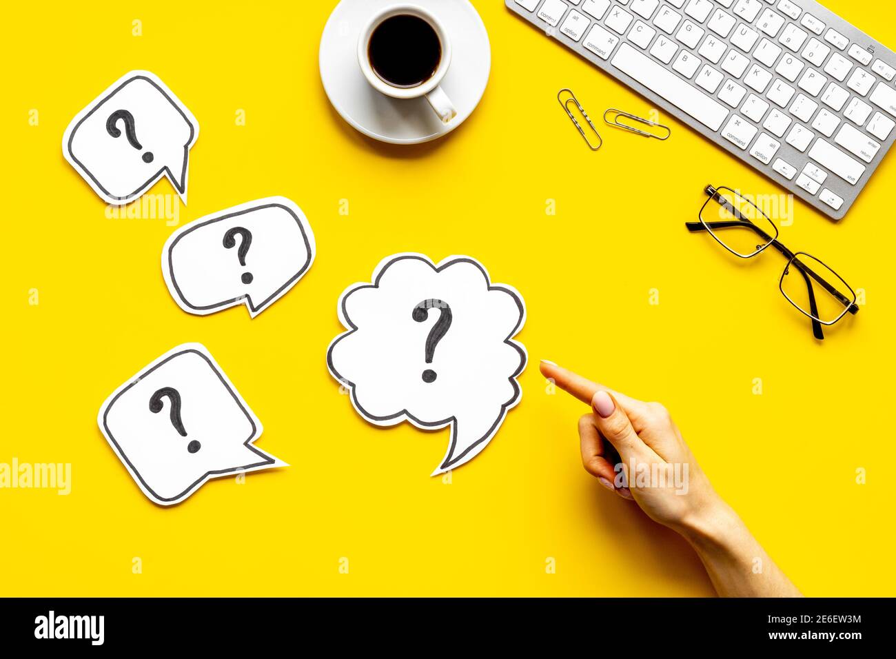 Question mark on speech bubbles with hand, top view. Solution concept Stock Photo