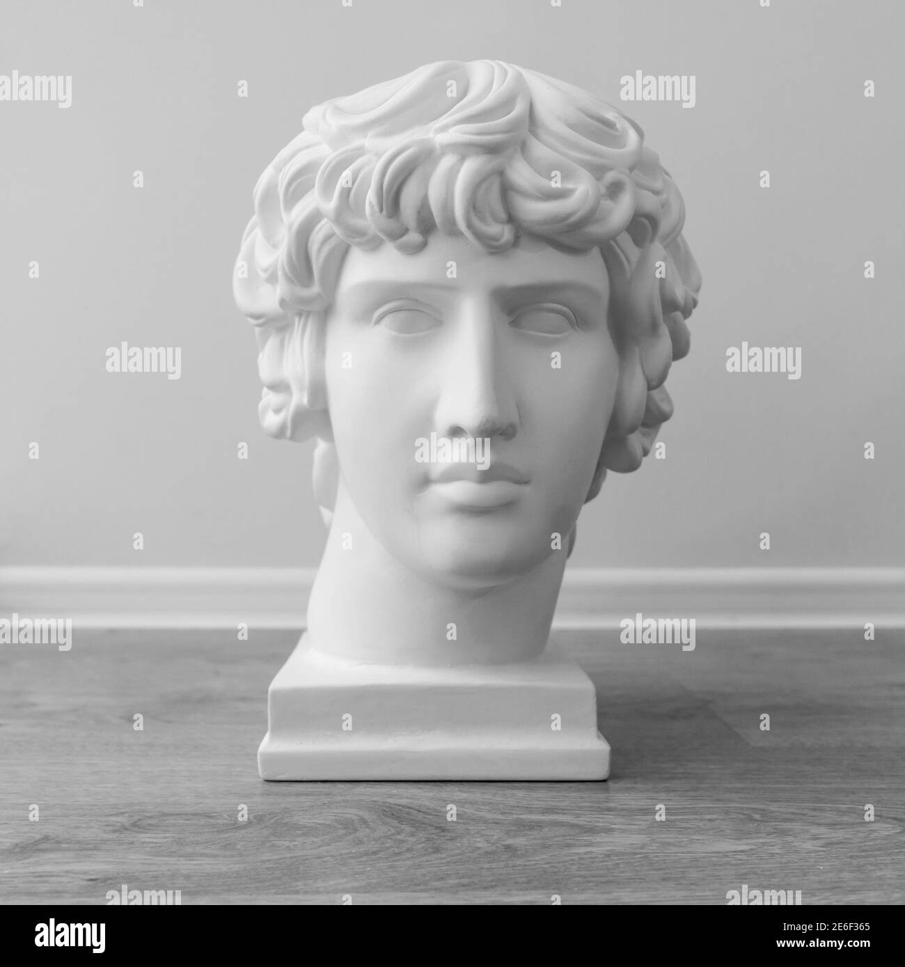 White plaster bust sculpture portrait of a young man. Black and white photo. Stock Photo
