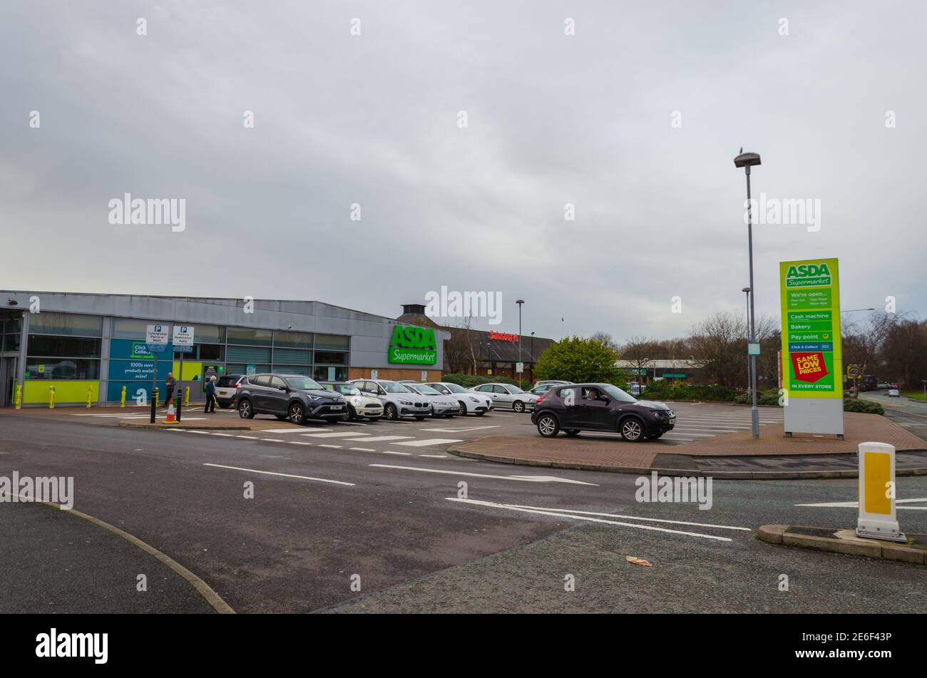 Flint; UK: Jan 28, 2021: Cars parked in front of Asda supermarket which is located beside a Sainsbury's supermarket. Stock Photo