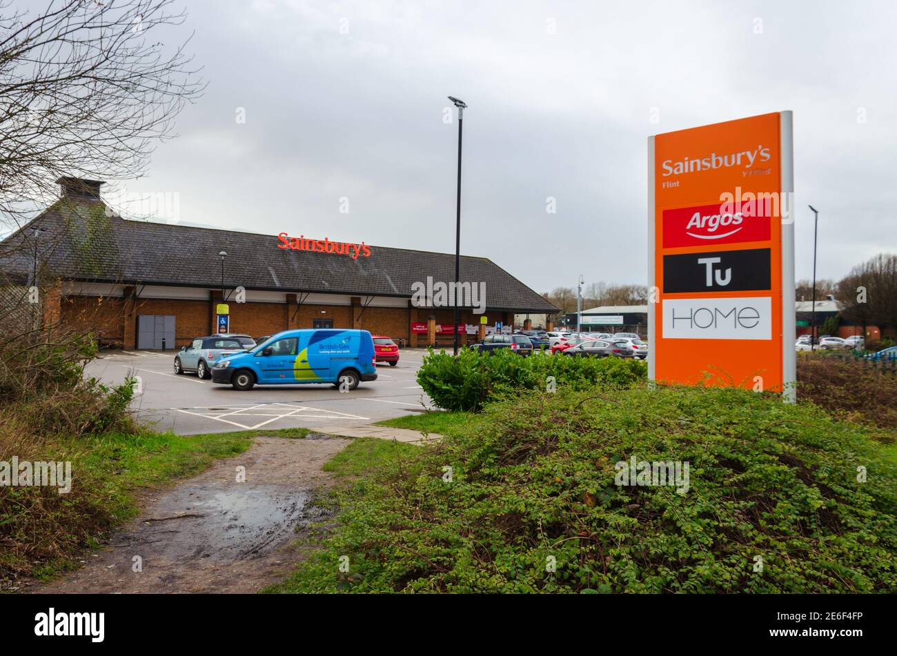 Flint; UK: Jan 28, 2021: Signage beside a Sainsbury's supermarket shows some of the instore brands, including Argos who recently relocated to inside t Stock Photo