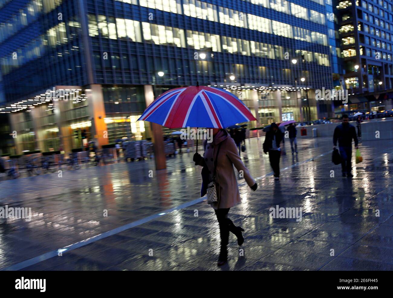 Workers walk in the rain at the Canary Wharf business district in London, Britain November 11, 2013. REUTERS/Eddie Keogh/File Photo Stock Photo