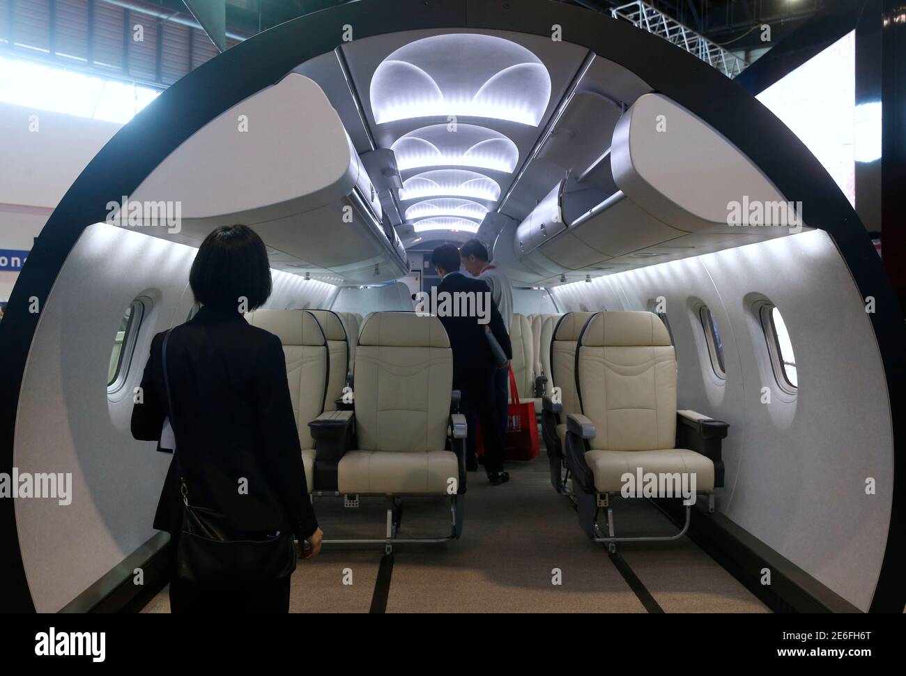 A visitor is shown the mock up of a cabin at the Mitsubishi Regional Jet booth during the opening day of the Singapore Airshow at Changi Exhibition Center February 16, 2016. Mitsubishi Aircraft Corp, a unit of Mitsubishi Heavy Industries Ltd, has struck a deal to supply 20 regional jets to U.S. leasing firm Aerolease, its first agreement with a lessor. REUTERS/Edgar Su Stock Photo