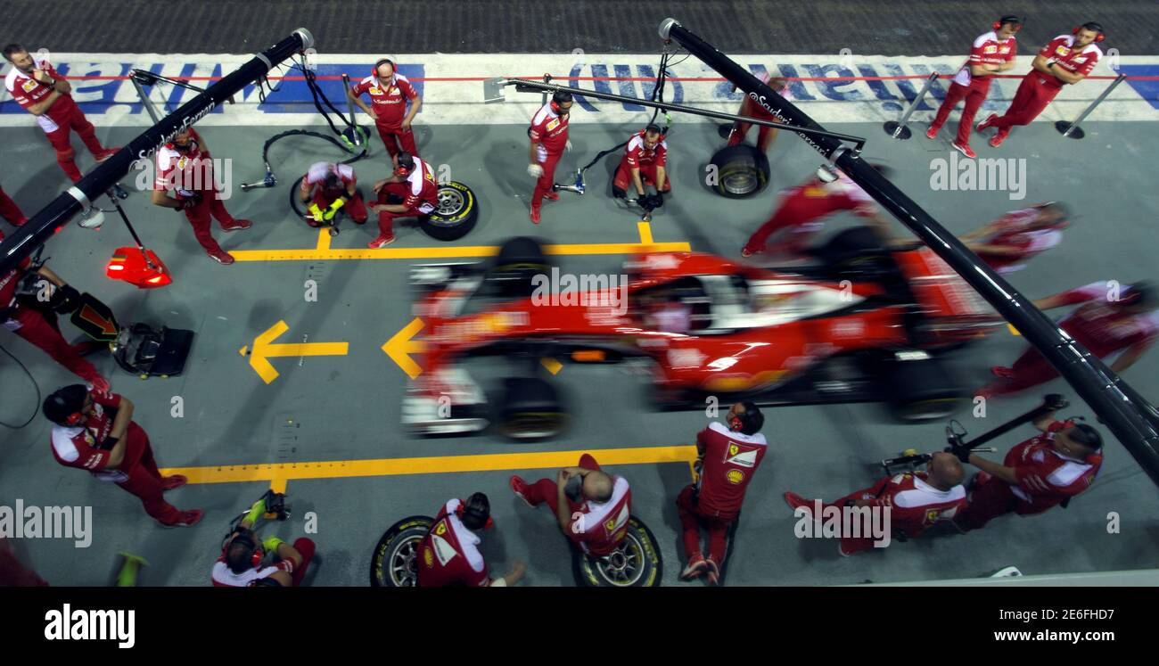 Ferrari Formula One pit crew practise changing tyres in the pit ahead
