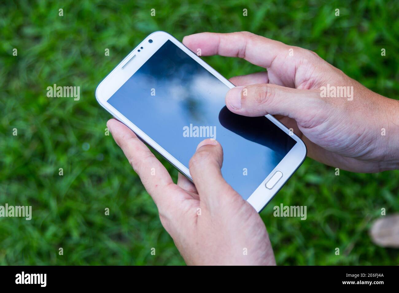 Close up man using mobile smart phone green background Stock Photo - Alamy