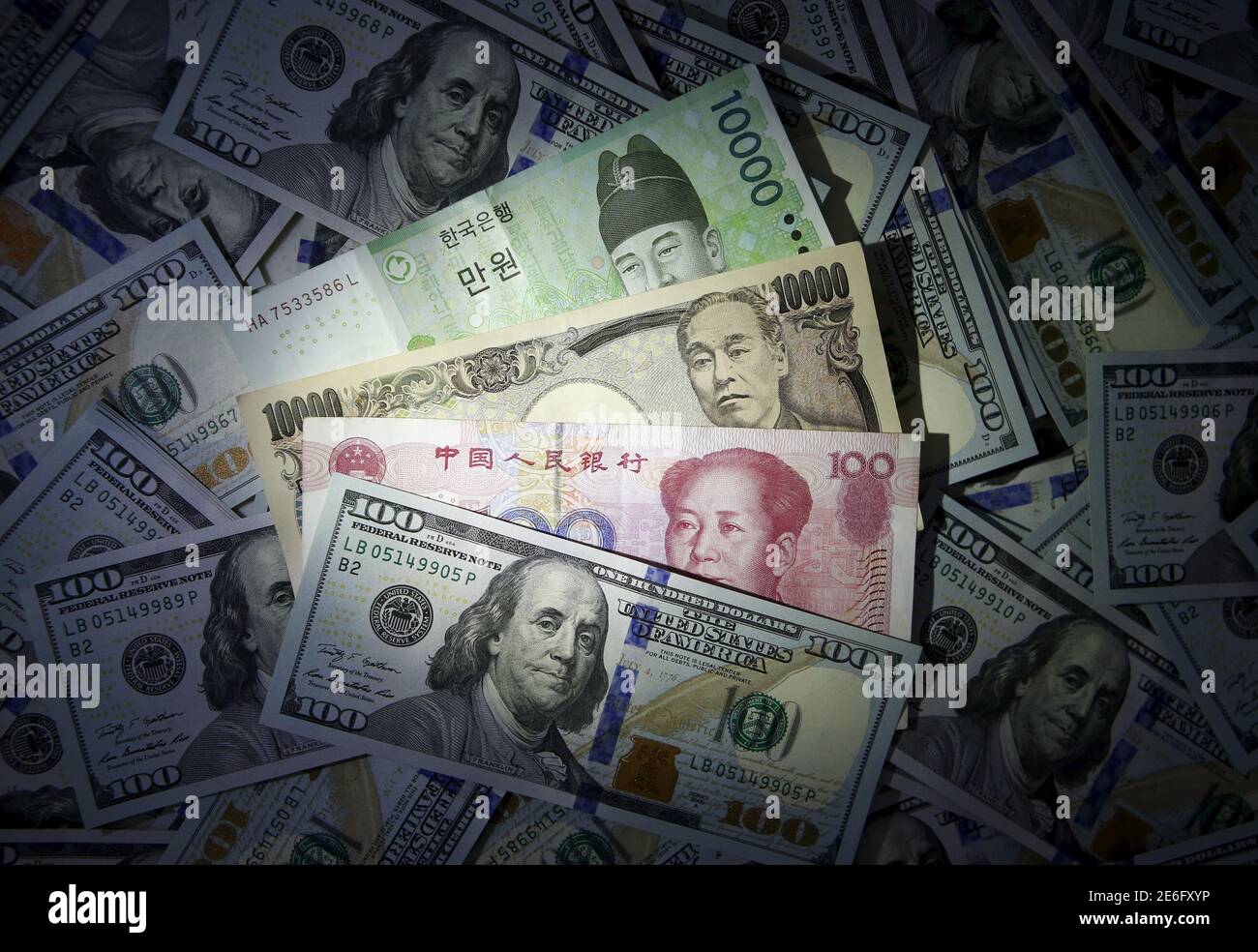 South Korean Chinese yuan and Japanese yen notes are seen on U.S. 100 dollar notes in this picture illustration taken in Seoul, South Korea, December 15, 2015. As brace for