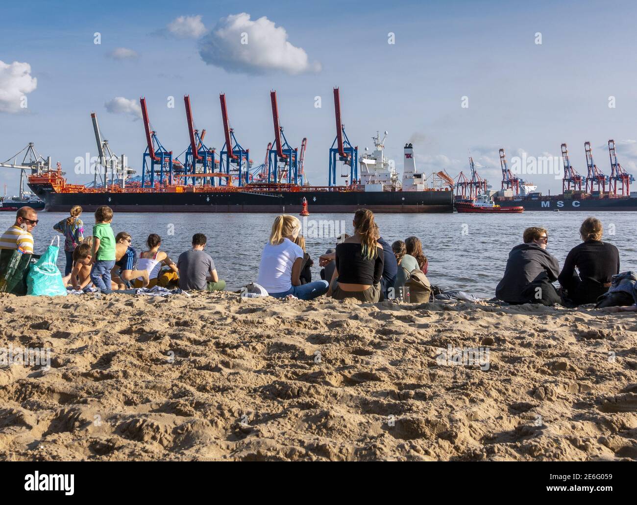 Locals and tourists relaxing in the sun on the sandy Elbstrand beach on ...