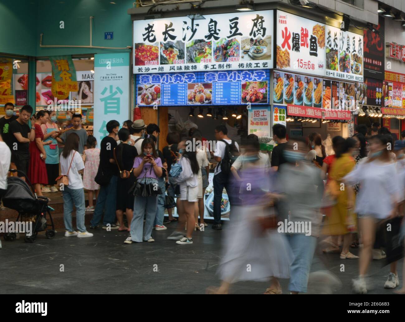 Some people stand still while others move quickly around the food stalls in dongmen street, Shenzhen, China. Stock Photo