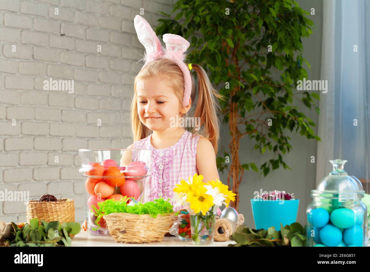 Happy little girl with bunny ears getting ready for Easter party Stock Photo