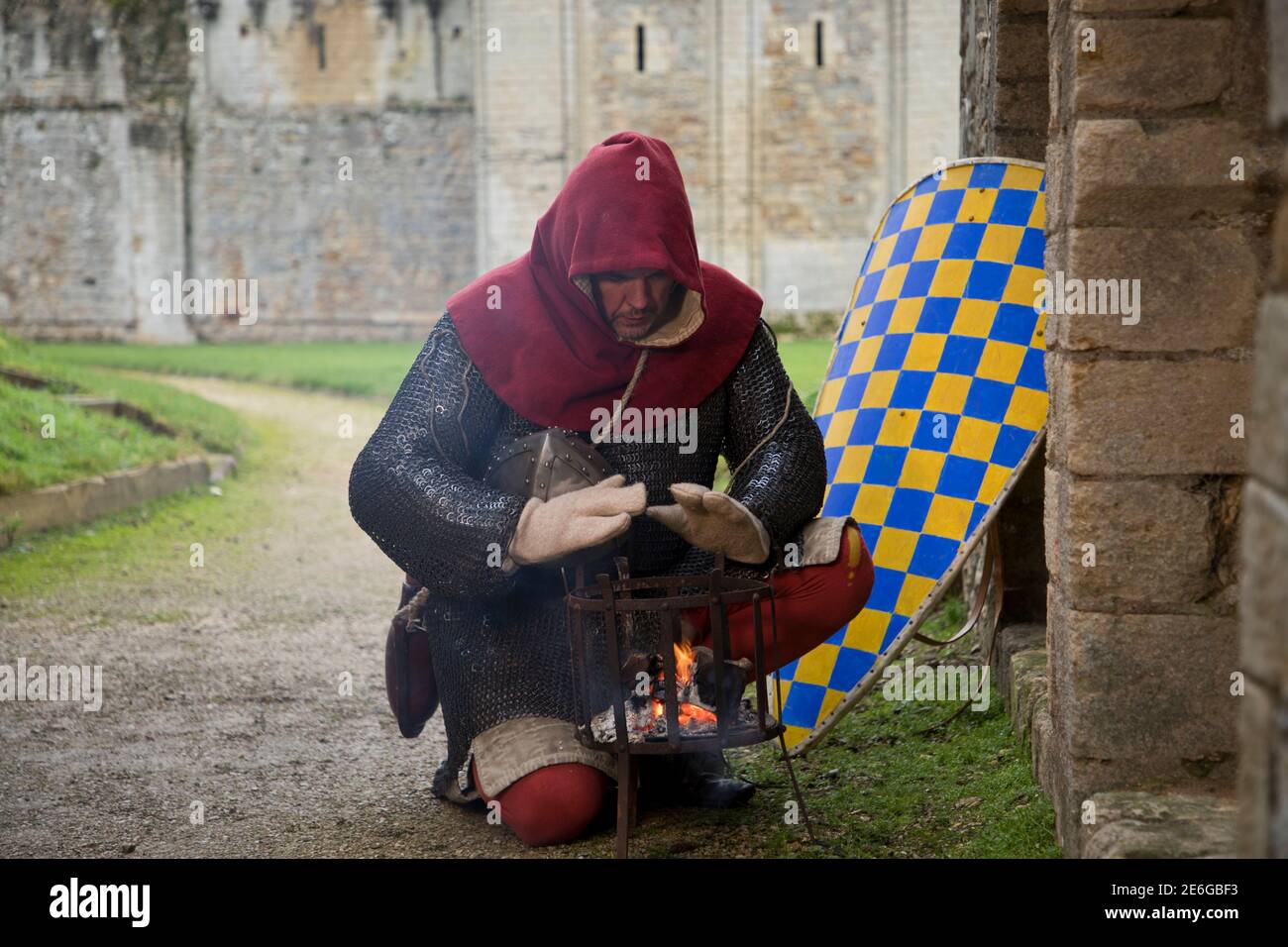12th century soldier keeping warm by brazier outside 12th century castle Stock Photo