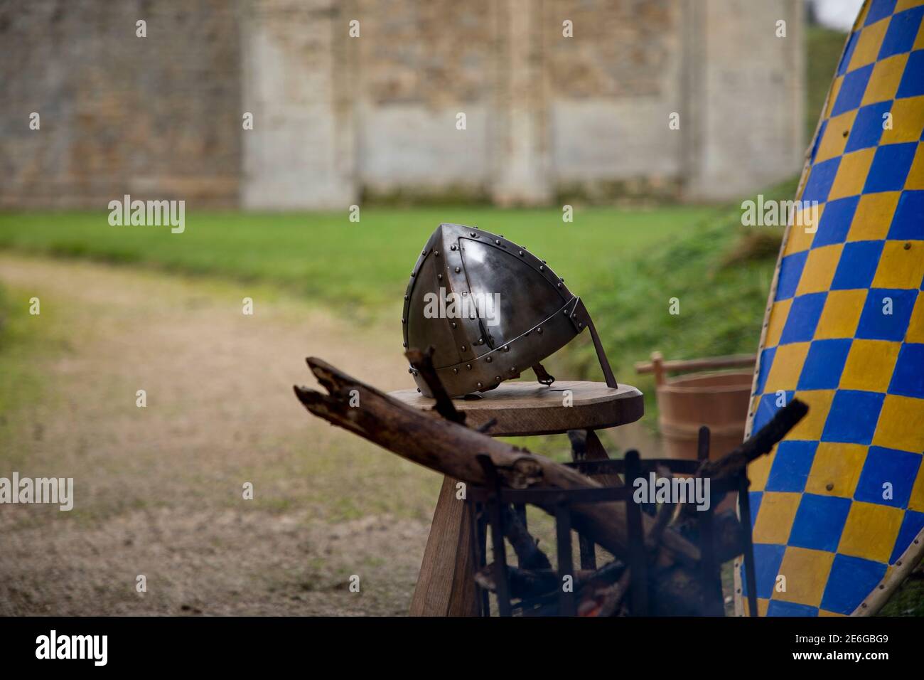 Medieval soldier's shield and helmet by brazier outside 12th century castle Stock Photo