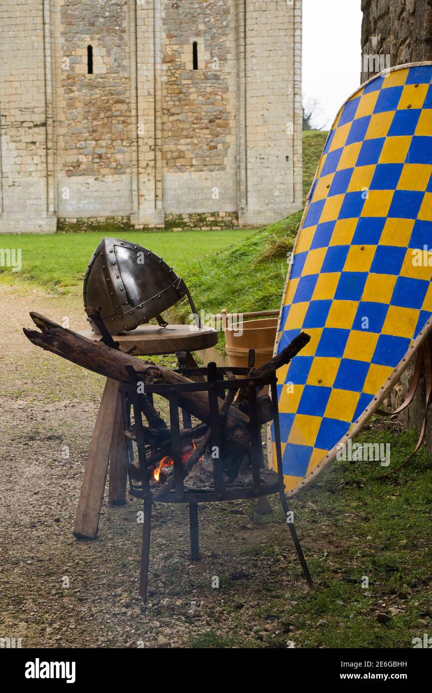 Medieval soldier's shield and helmet by brazier outside 12th century castle Stock Photo