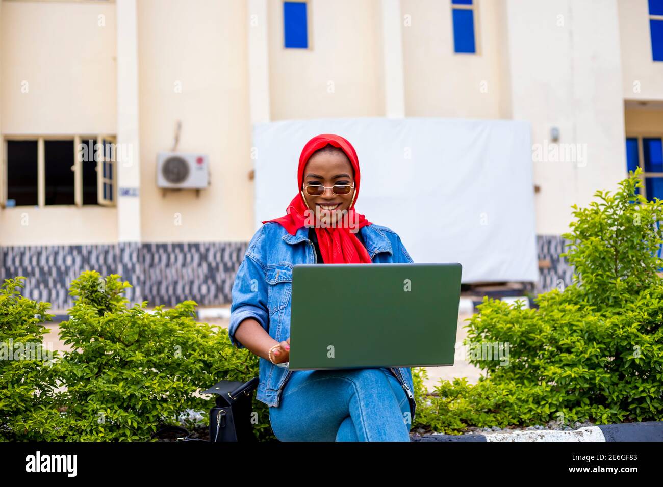 young black beautiful lady sitting out and working on her laptop and ...