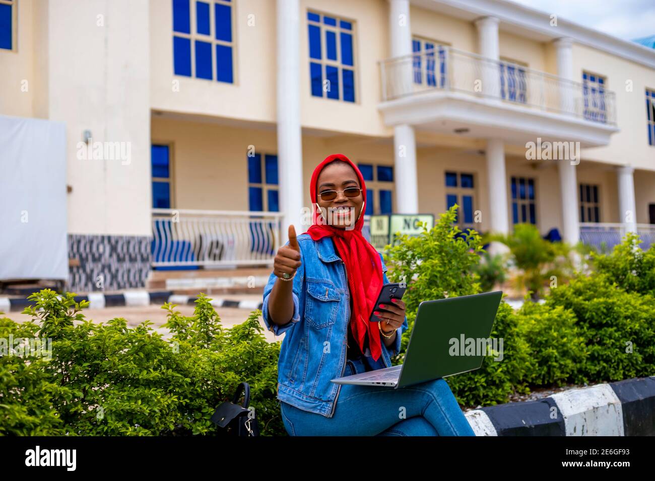 young black beautiful lady sitting out and working on her laptop and ...