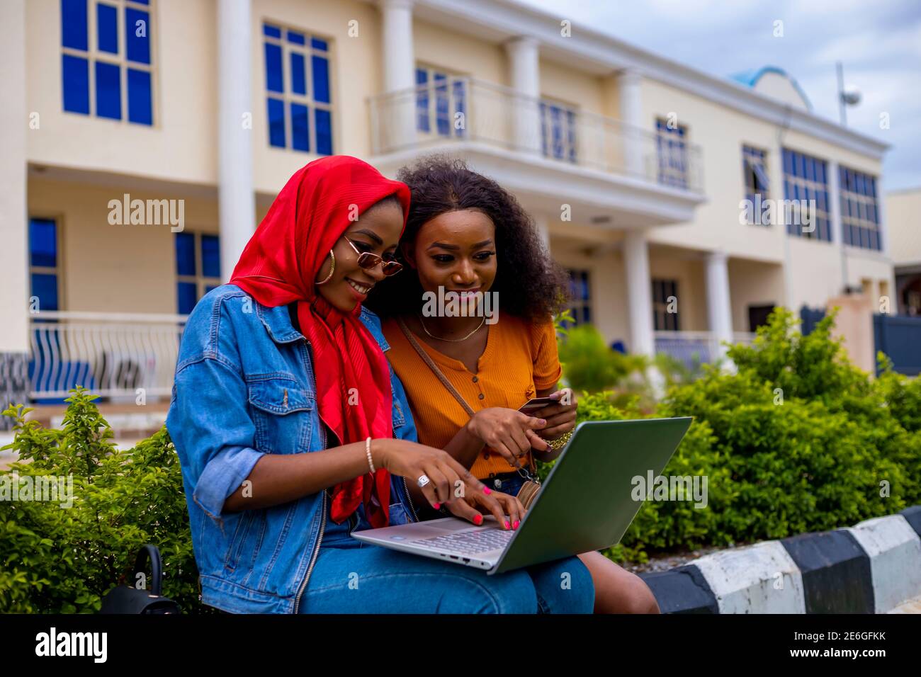 young black beautiful ladies sitting out and working on her laptop ...