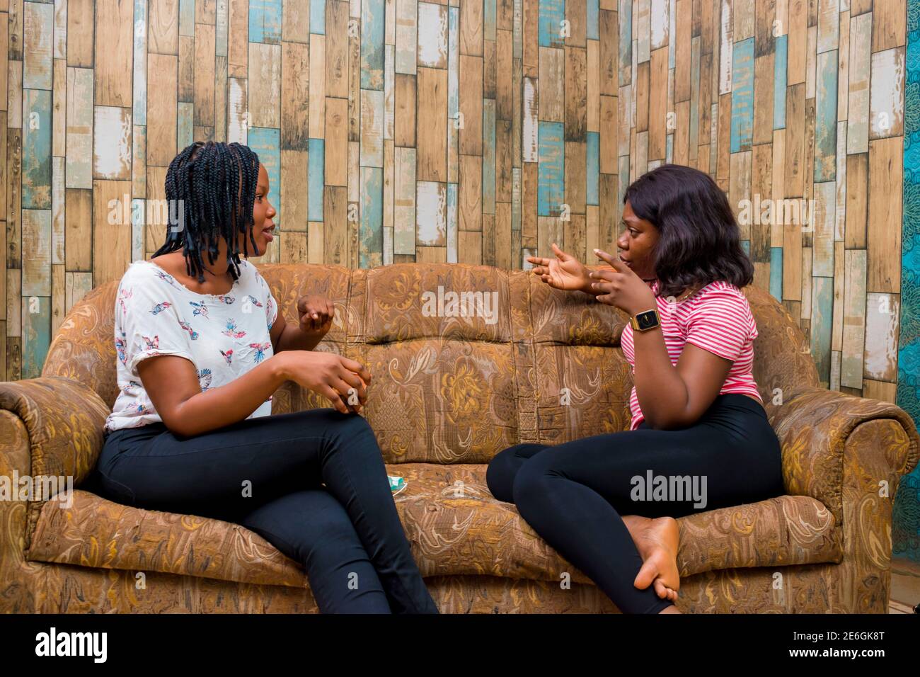 young black ladies sitting on a couch, discussing and making some jokes Stock Photo