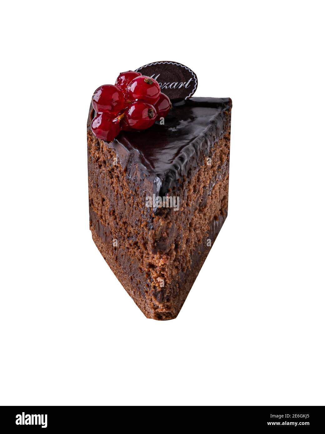 Piece of dark chocolate cake called Mozart decorated with glazed red currant berries. Piece of cake is isolated on white background without shadow. Stock Photo