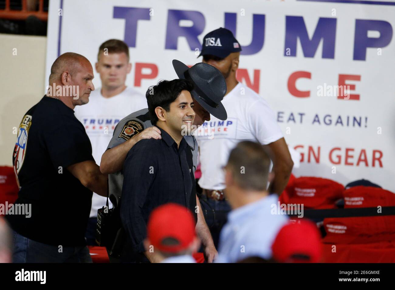 A protester is ejected by a Bikers for Trump member and law enforcement officer as U.S. President Donald Trump appears on stage at a rally in Harrisburg, Pennsylvania, U.S. April 29, 2017.   REUTERS/Carlo Allegri Stock Photo