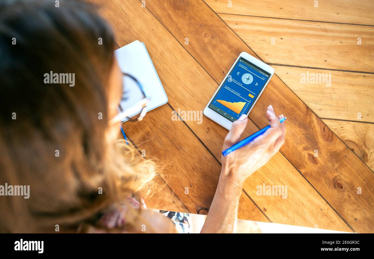 Businesswoman looking mobile ethereum information Stock Photo