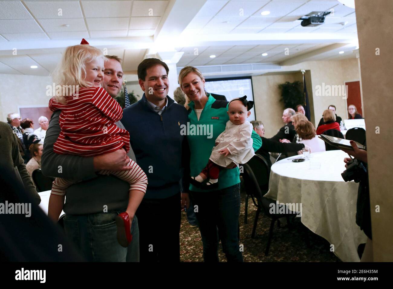 U.S. Republican presidential candidate and U.S. Senator Marco Rubio stands for a photo with Charlotte Meehan (3 yrs old) Jonathan Meehan, Heather Meehan who holds her daughter Katie Meehan 8 months old at a Miami Dolphins versus New England Patriots watch party in Atkinson, New Hampshire, January 3, 2016.  REUTERS/Katherine Taylor Stock Photo
