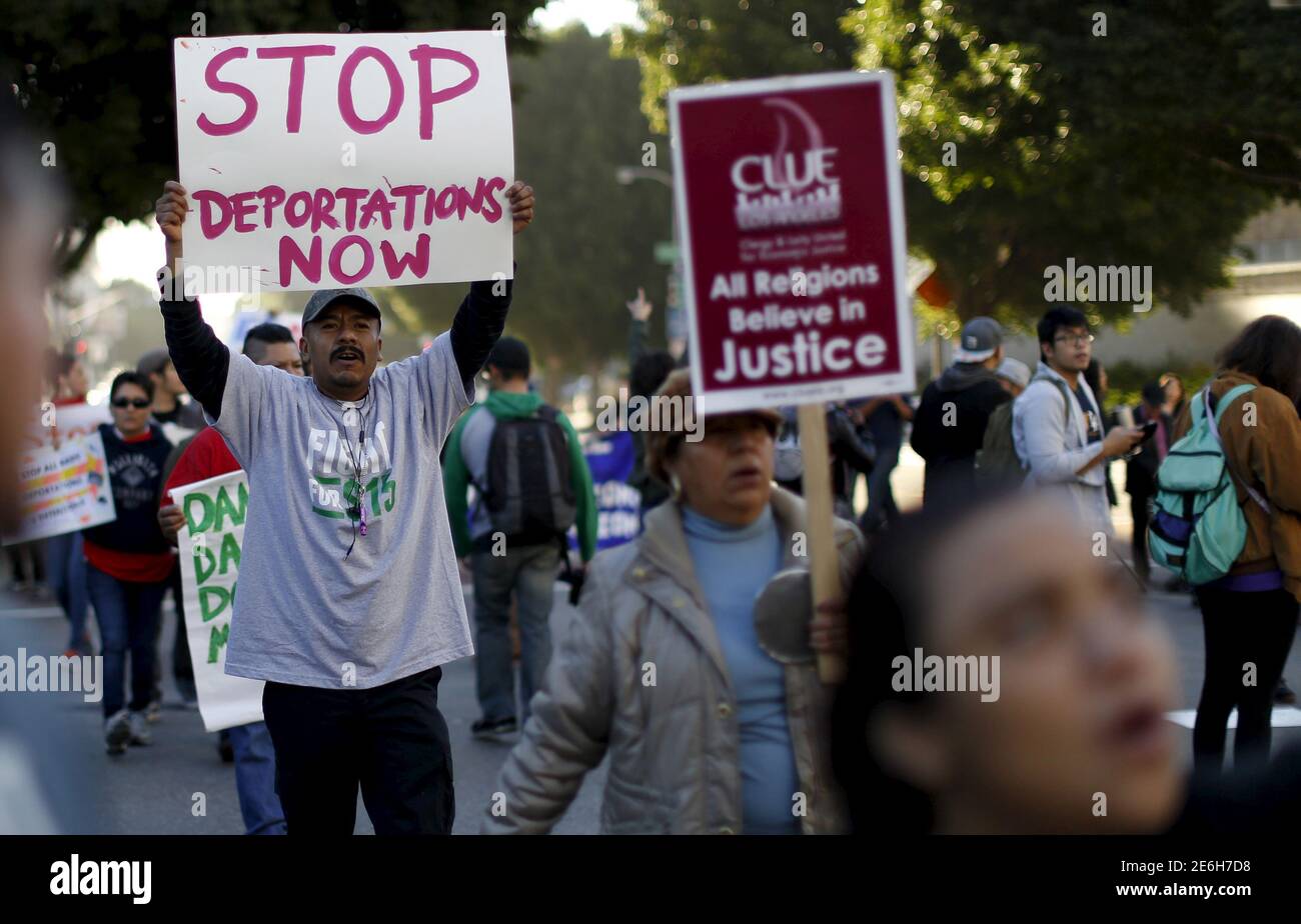 People hold signs as they gather outside a Federal Building while protesting against Immigration and Customs Enforcement (ICE) raids on Central American refugees in Los Angeles, California January 26, 2016.   REUTERS/Mario Anzuoni Stock Photo