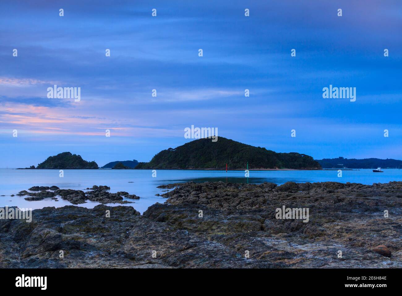 The view from Paihia in the Bay of Islands, New Zealand, at dusk. The large island in the ocean is Motumaire Stock Photo