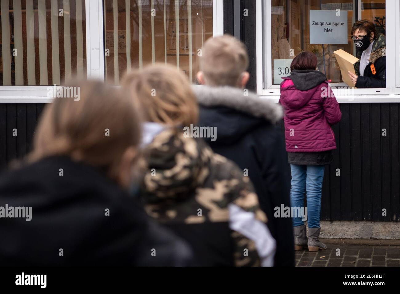Stadland, Germany. 29th Jan, 2021. Kerstin Schermer, secretary at the Oberschule Rodenkirchen, hands the students their report cards from the secretary's window. Credit: Sina Schuldt/dpa/Alamy Live News Stock Photo