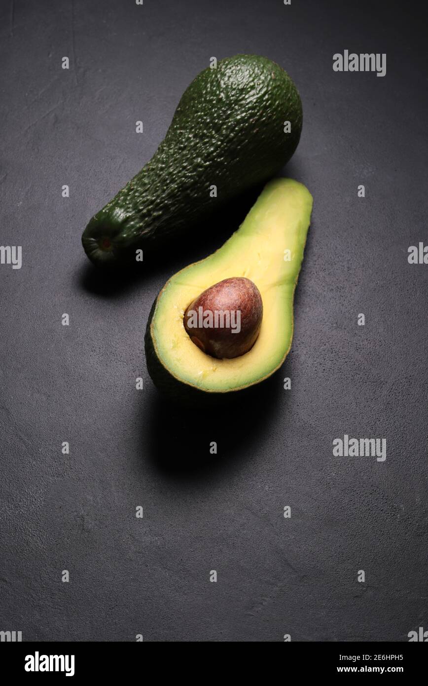 Fresh avocado isolated on dark background. Vegetarian food concept. Top view. Stock Photo