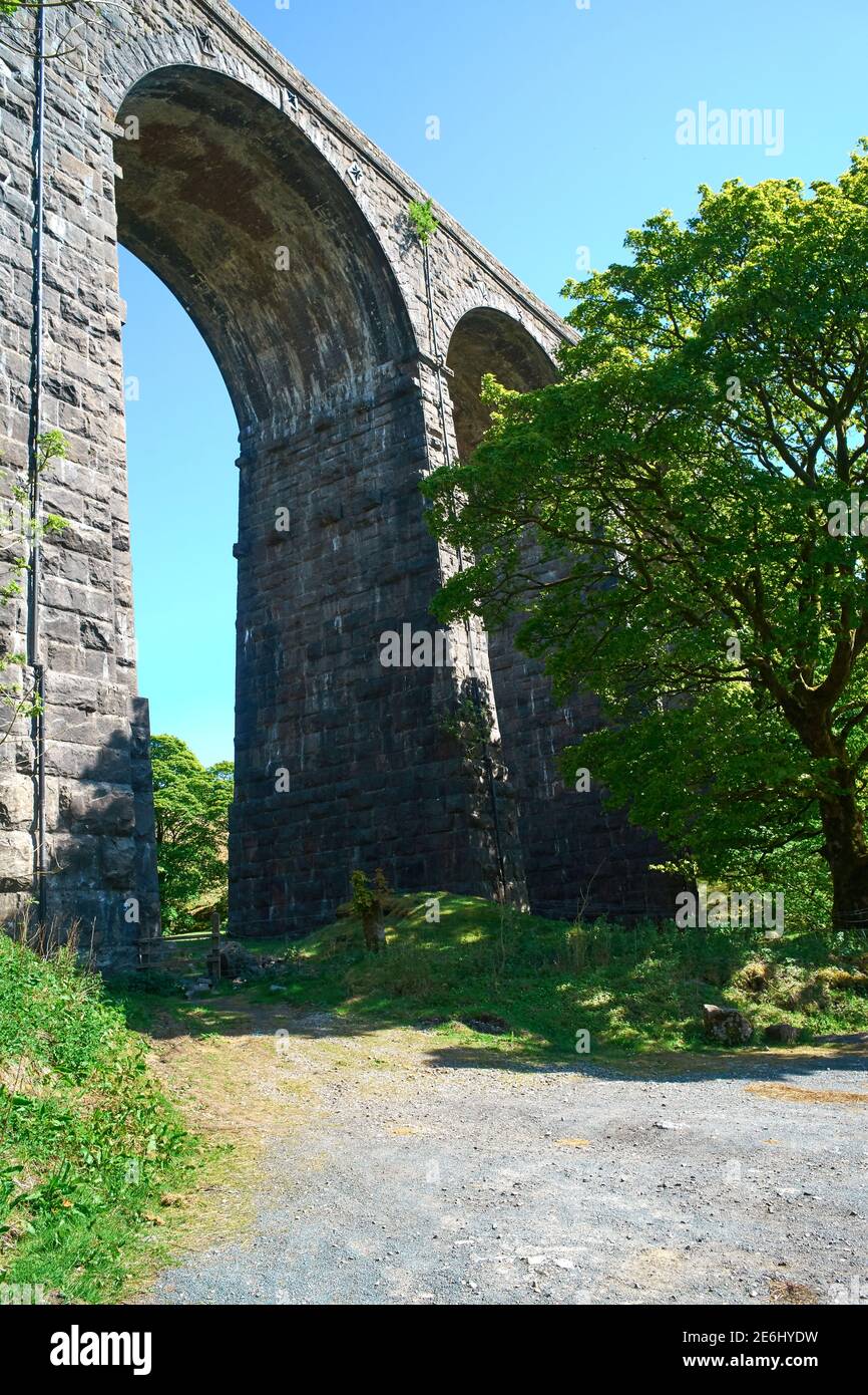 A stone built railway viaduct on a sunny day in the Yorkshire Dales showing 2 arches under a blue sky Stock Photo