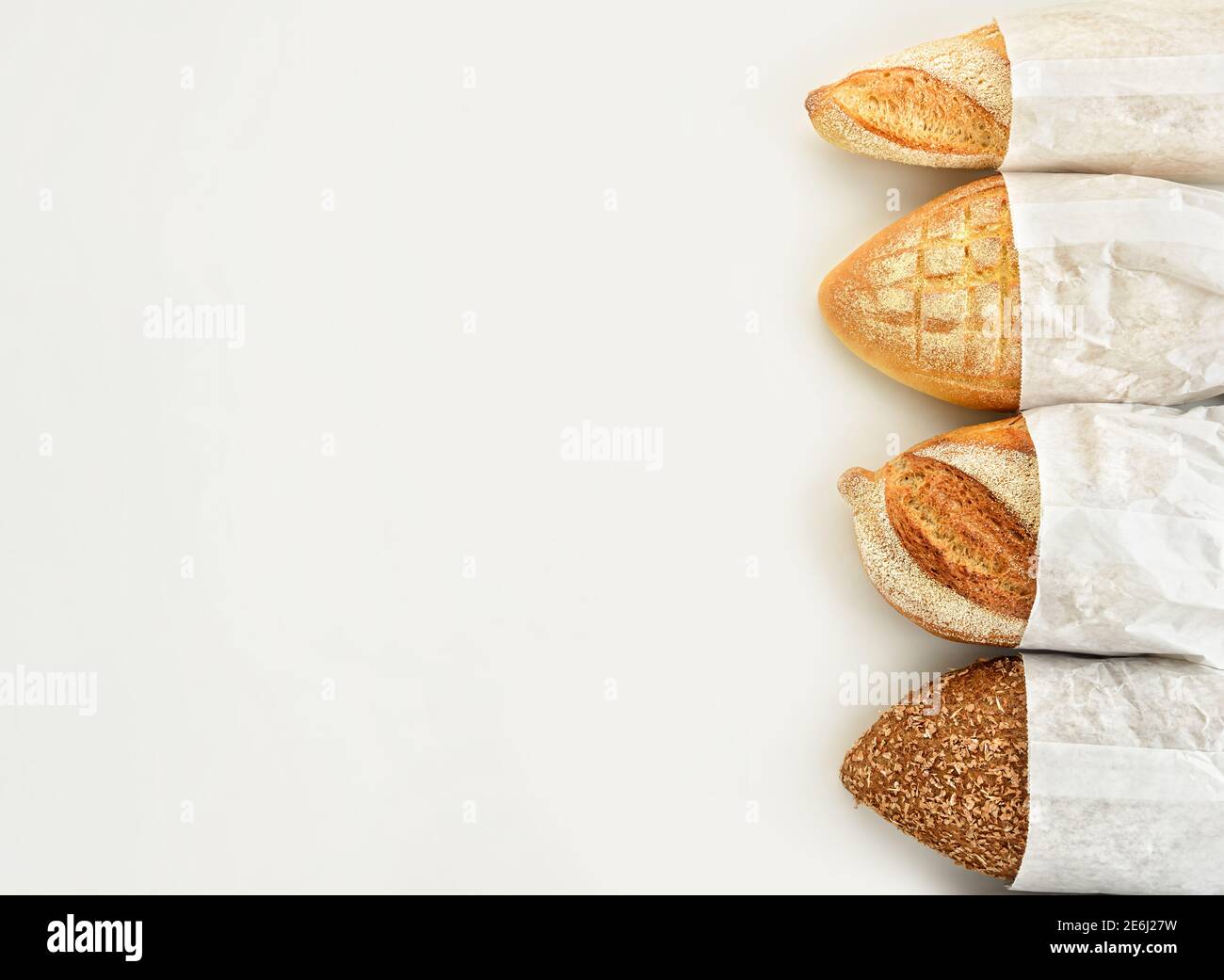 Different types of bread in paper bags on a white background. Top view ...