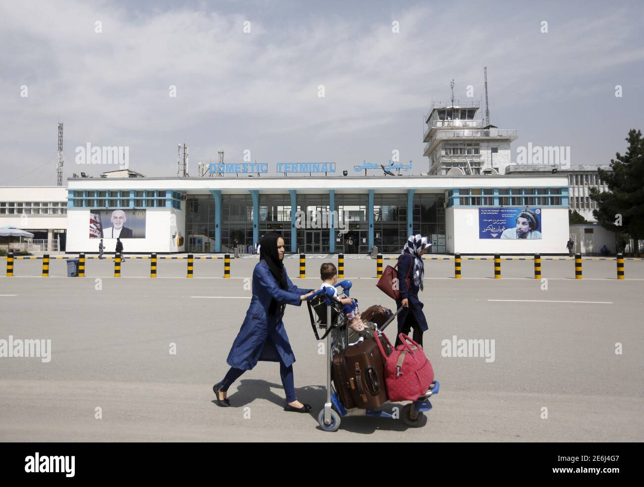 Afghan passengers walk in front of Hamid Karzai International Airport in Kabul, Afghanistan March 29, 2016.  REUTERS/Omar Sobhani Stock Photo