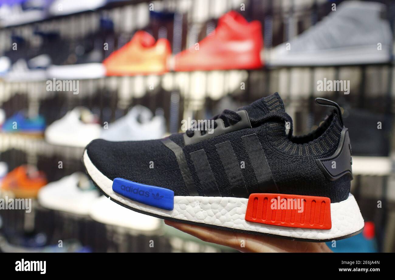 A shop assistant presents the new Adidas NMD model at the flagship store in  Berlin, Germany, January 20, 2016. A combination of new and retro sneaker  styles will keep driving growth at