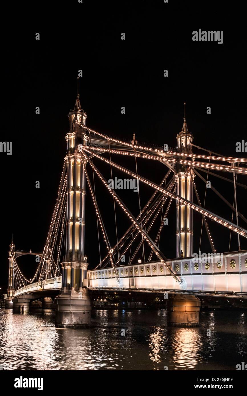 Albert Bridge, illuminated at night, connecting Chelsea and Battersea over the River Thames, Battersea, London, United Kingdom Stock Photo