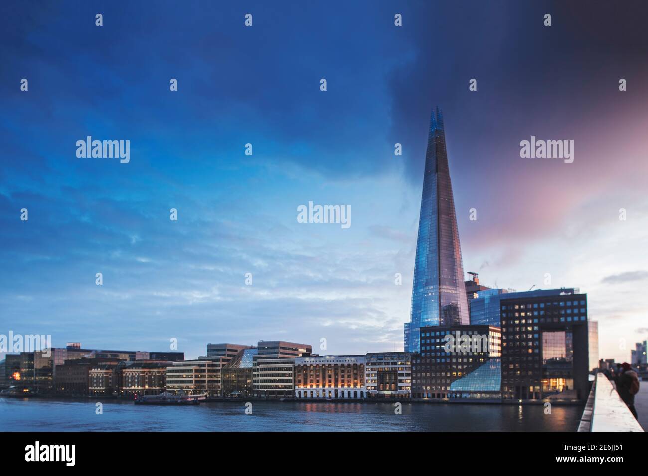 The London skyline from London Bridge, looking south over the river Thames to Southwark & Bermondsey, Shard skyscraper, London Bridge Hospital, dusk Stock Photo