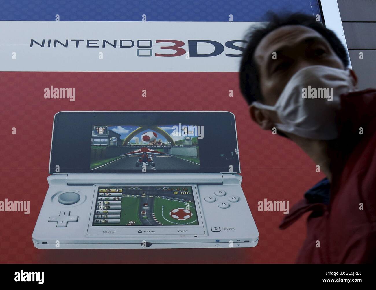 A pedestrian walks past an advertisement board of Nintendo Co Ltd's 3DS  portable game console outside an electronics retail store in Tokyo, Japan,  February 2, 2016. Japan's Nintendo Co reported a 5.3