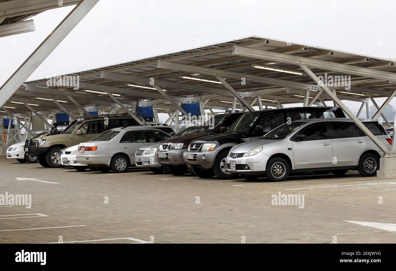 Cars are seen parked under solar panels of a solar carport at the Garden City shopping mall in Kenya's capital Nairobi, September 15, 2015. The Africa's largest solar carport with 3,300 solar panels will generate 1256 MWh annually and cut carbon emission by around 745 tonnes per year, according to Solarcentury and Solar Africa.  REUTERS/Thomas Mukoya Stock Photo