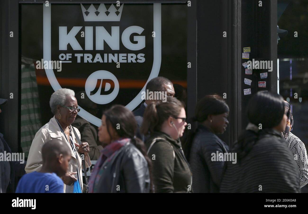 People pass a JD Sports store in London, Britain April 11, 2017.  Shares in Britain's JD Sports Fashion Plc climbed to a record high after strong demand for leisure clothing helped to drive a 55 percent rise in headline annual pretax profit, its biggest increase in eight years REUTERS/Neil Hall Stock Photo