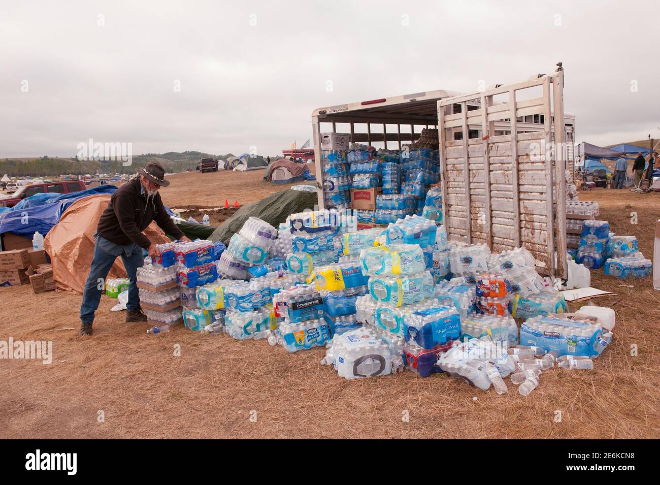 A volunteer stacks cases of donated water in an encampment that has grown on the banks of the Cannon Ball River with the purpose of stopping construction of the  Energy Transfer Partners Dakota Access oil pipeline near the Standing Rock Sioux reservation in Cannon Ball, North Dakota, U.S. September 6, 2016.  REUTERS/Andrew Cullen Stock Photo