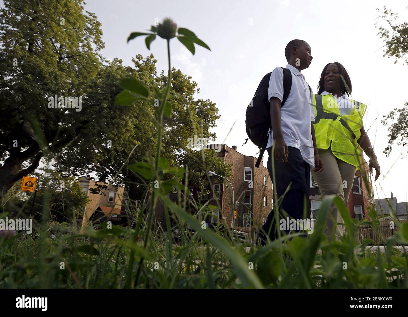 Safe Passage worker Irene Fonder walks with a Sherwood Elementary School  student in the Englewood neighborhood in Chicago, Illinois, United States,  September 8, 2015. The fourth-largest U.S. public school system is not