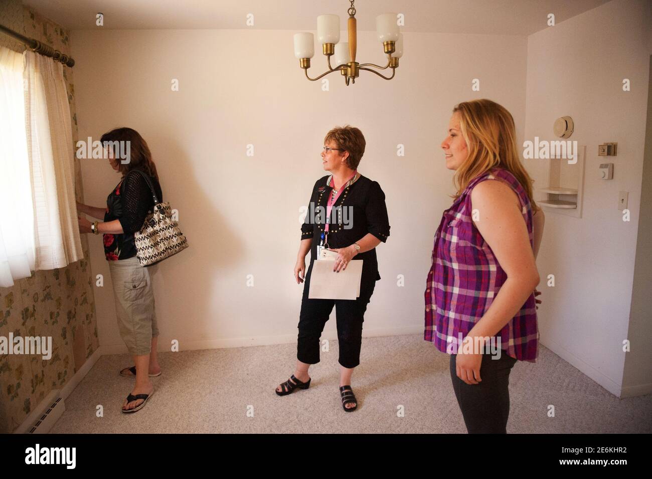 Real estate broker Lorrie Nantt (Center) shows a house to prospective buyers in Dickinson, North Dakota June 26, 2015. Nantt and her business partner, Marie Swenson, opened a RE/MAX franchise in 2014. The women of North Dakota's oil patch are fighting back. In dozens of interviews, women across the No. 2 U.S. oil producing state are flatly rejecting the widespread perception that prostitution or stripping are their only career paths amidst the bustle of the stereotypically male-dominated oilfield economy.  REUTERS/Andrew Cullen Stock Photo