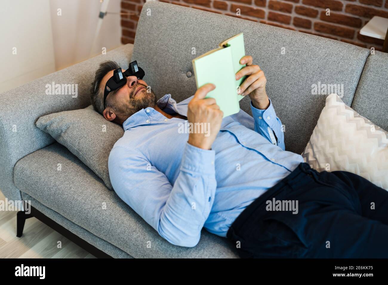 Man Using Lazy Reading Prism Glasses To Read Book Stock Photo