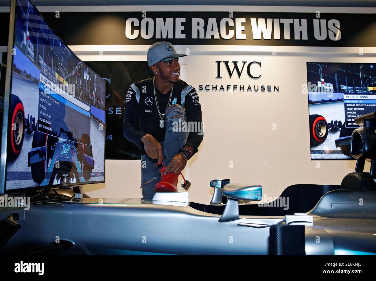 Mercedes' Lewis Hamilton of Britain laces his shoe at a driving simulator at a publicity event ahead of the Singapore F1 Grand Prix Night Race September 14, 2016. REUTERS/Edgar Su Stock Photo