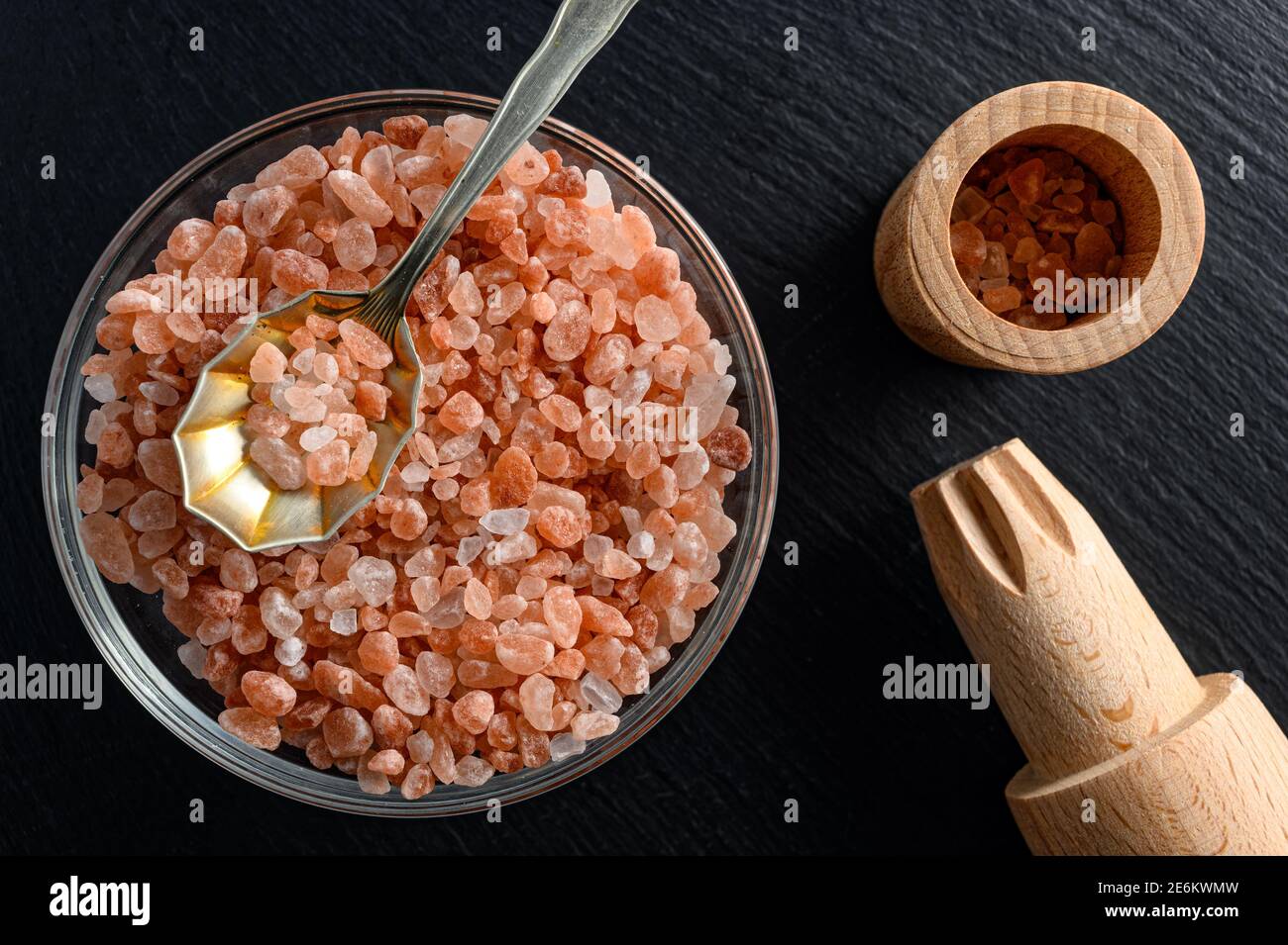 Glass bowl of himalayan salt with small spoon and wooden salt mill on ...