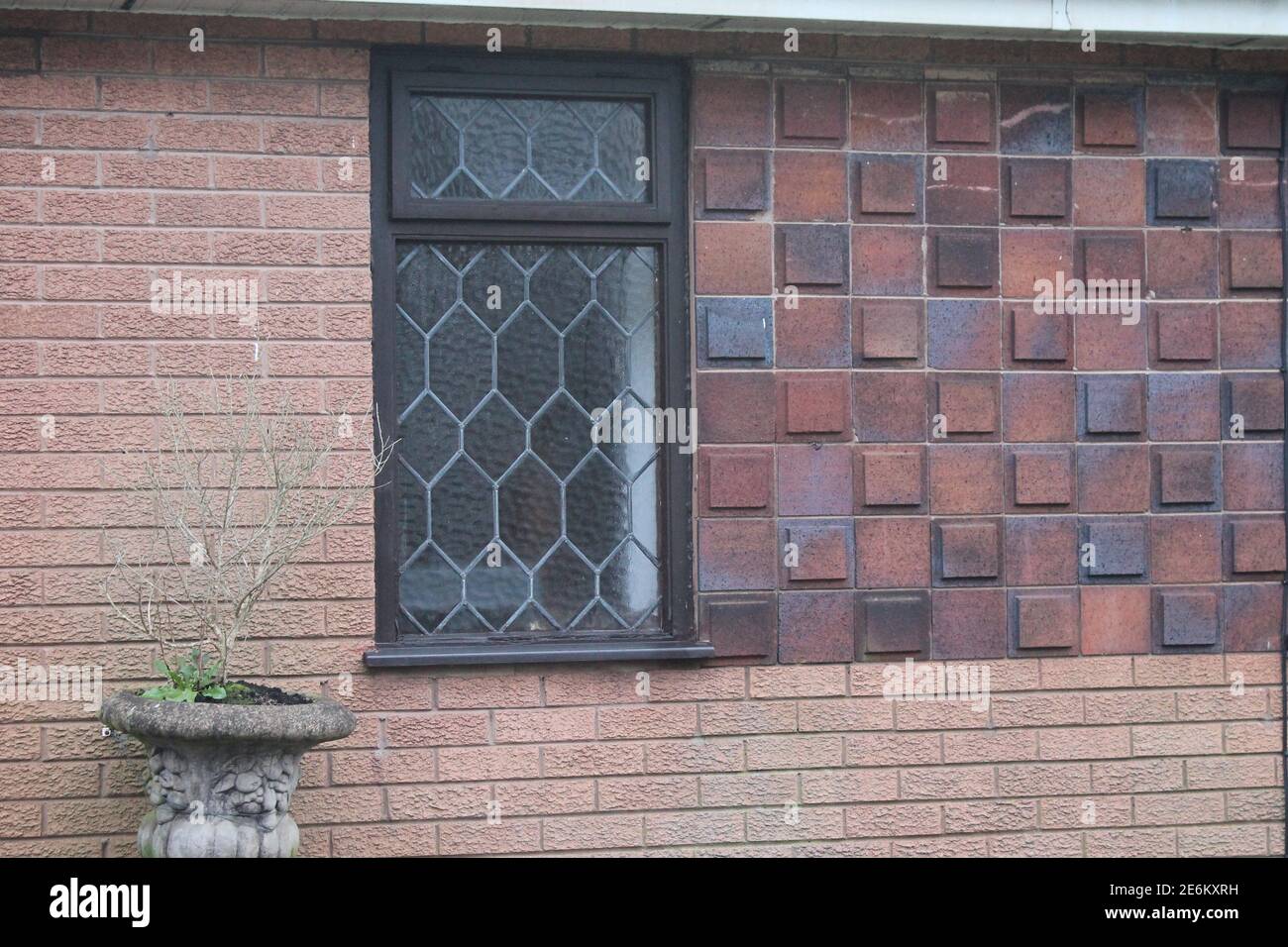 Red and blue grey decorative raised tiles on the front of a house Stock Photo