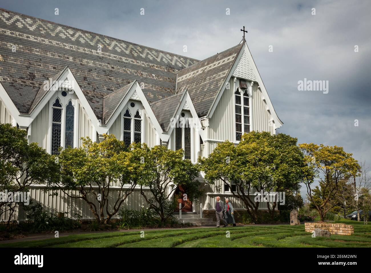 Horizontal lateral shot of an old couple strolling around the Holy Trinity Cathedral in Parnell district, Auckland, North Island, New Zealand Stock Photo